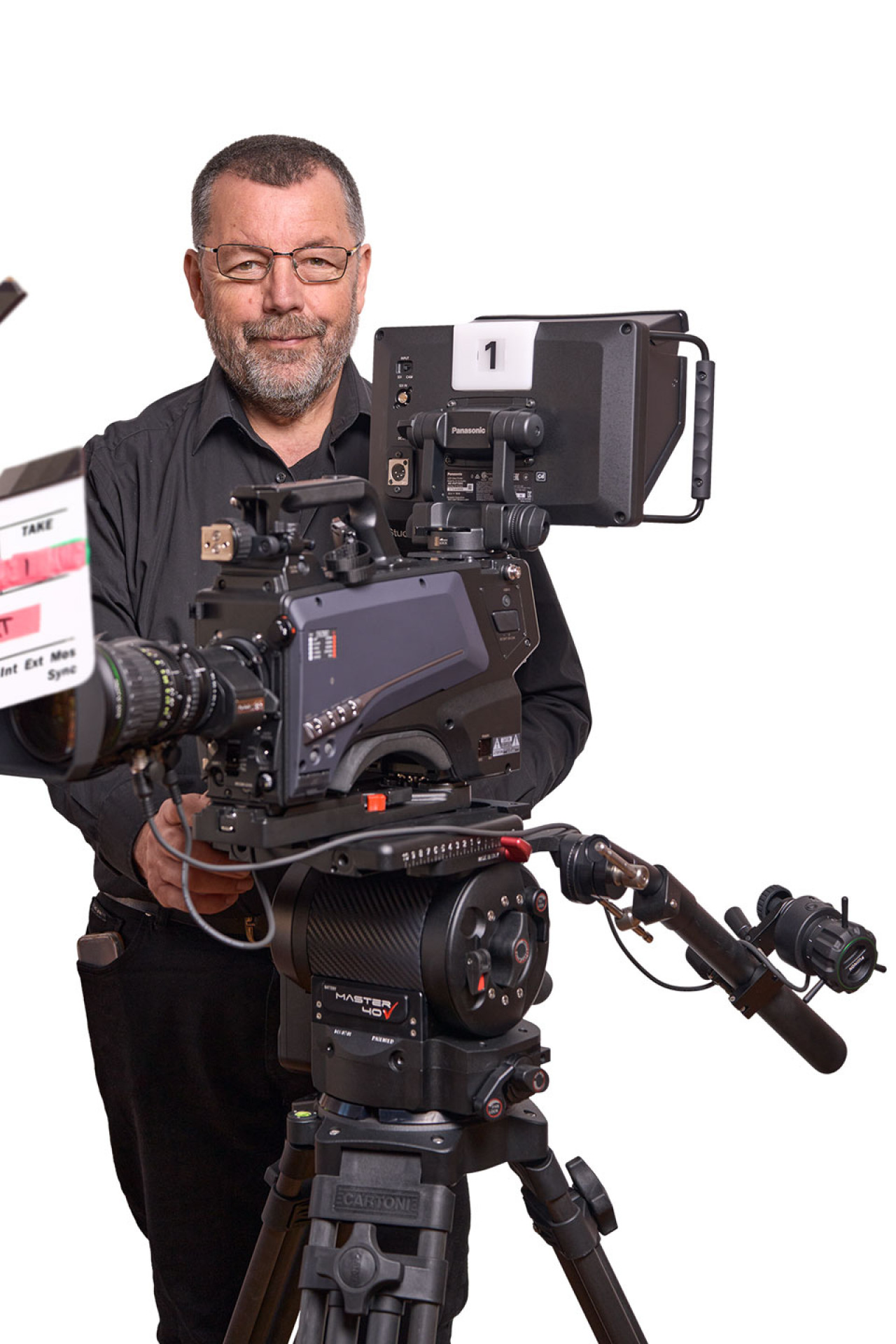 Seniorchef Rolf steht vor einem großen Stativ mit Kamera.